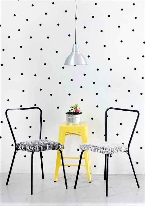 sedie nere con tavolino giallo e carta da parati a pois neri